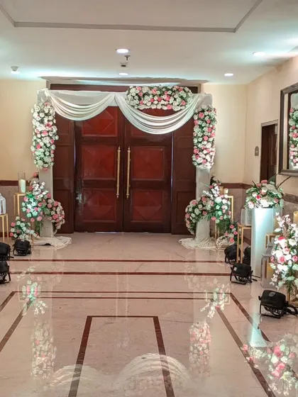 The entrance to the Holy Communion celebration, decorated with beautiful arches of pink and white flowers. The soft, welcoming design sets a serene and celebratory tone for the sacred event.