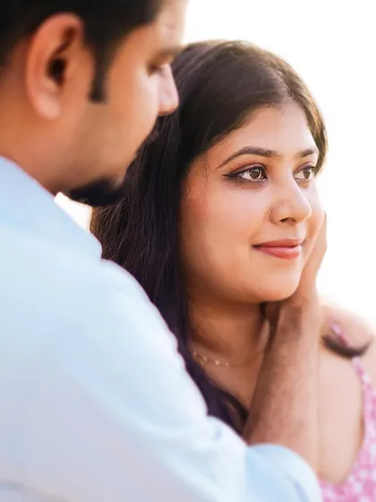 A close-up portrait capturing a tender moment. The soft light and tight framing focus entirely on the couple's emotion and connection.