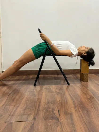 This supported Purvottanasana variation uses a chair and blocks for head support. It allows for a longer hold, enabling the practitioner to relax into the pose and experience its restorative benefits.
