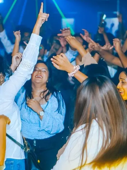 A group of friends with their hands up, united by the music. This is the community I build.