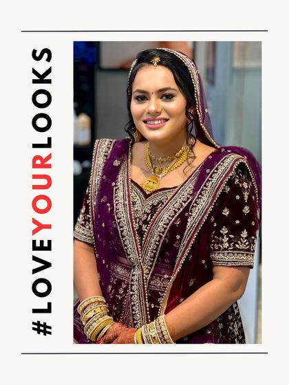 A radiant bridal look featuring a beautiful smile. The makeup is centered around glowing skin and well-defined features, with a simple gold jewelry set that complements her purple and silver embroidered outfit.