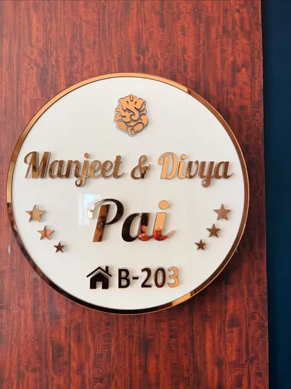 A close-up of the custom acrylic nameplate with rose gold lettering and a Ganesha motif.