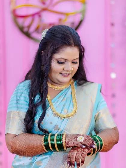 A duplicate of image 3, this candid moment shows the client admiring her mehndi. The soft focus on her face highlights the subtle and elegant makeup work.