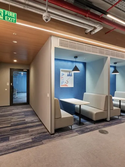 Booth seating along a corridor provides a convenient place for a quick chat or to take a phone call.