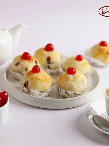 Let's go coconuts with our classic coconut macaroons. These chewy, sweet mounds are baked to a perfect golden brown and topped with a bright red cherry.