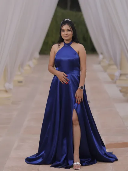 A client looking elegant in a satin blue gown. The makeup is glamorous and sophisticated, with a focus on her eyes and a flawless complexion.