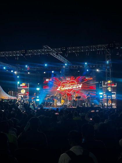 A wide shot of the Zubeen Garg concert, showing the impressive scale of the stage and the massive, energetic crowd.