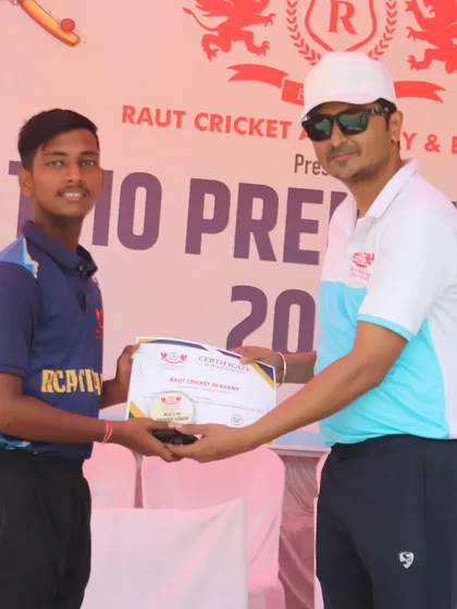 A young player from the RCA Titans is awarded his certificate for participation.
