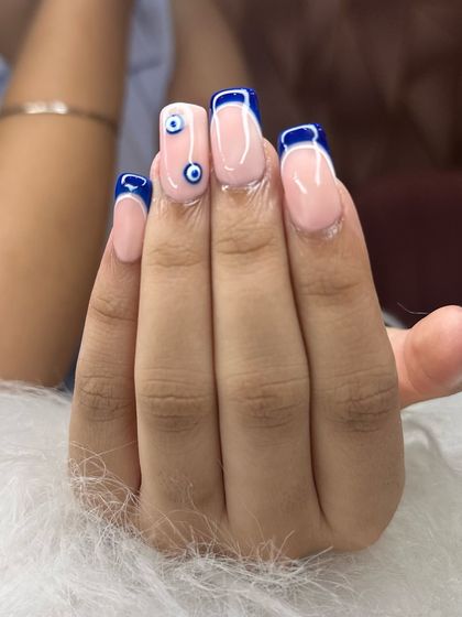 The full hand view of this trendy evil eye nail art, showing how the accent nails and French tips work together.