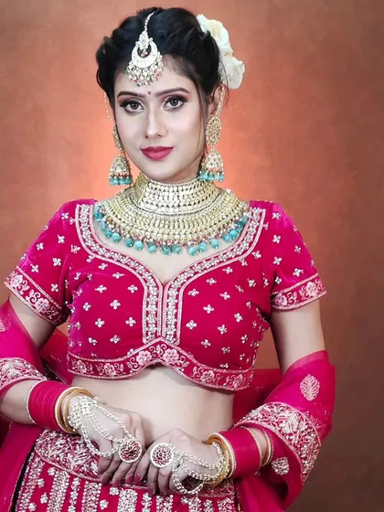 This vibrant magenta pink lehenga is perfect for a bride who wants a pop of colour. The outfit is complemented by a heavy turquoise-beaded Kundan choker.