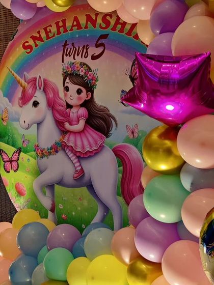 A close-up of a unicorn-themed backdrop, showing a girl riding a unicorn under a rainbow.