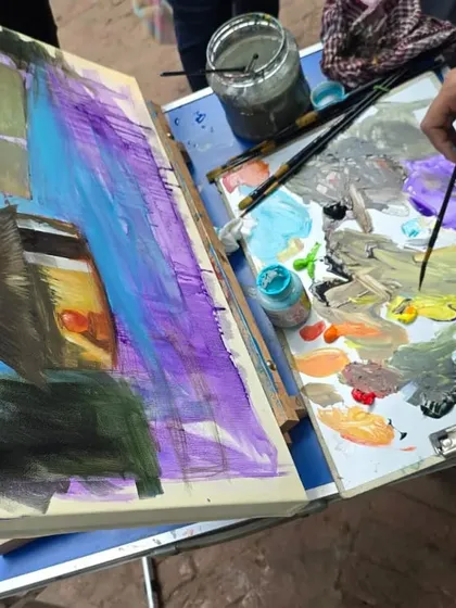 A close-up of an artist's palette and canvas during our outdoor painting session, showing the vibrant acrylic colors being mixed and applied.