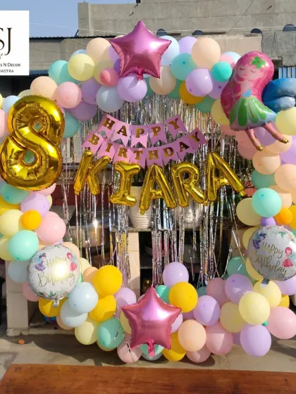 This circular balloon arch in pastel colors was the centerpiece for Kiara's 8th birthday fairy-themed party. The setup on the terrace created a beautiful photo opportunity.