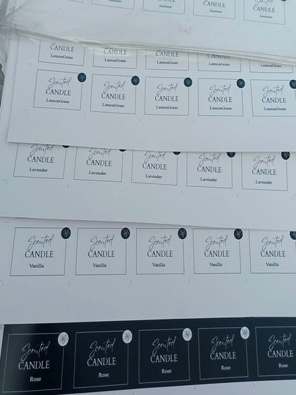 Stacks of freshly printed candle label sheets. I can handle bulk orders for your branding needs, ensuring all your products have consistent, high-quality labels.