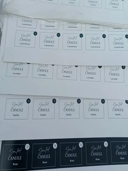 Stacks of freshly printed candle label sheets. I can handle bulk orders for your branding needs, ensuring all your products have consistent, high-quality labels.