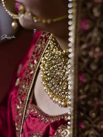 A close-up, artistic shot of the bride's magnificent gold necklace, showing the intricate craftsmanship of her wedding jewelry.