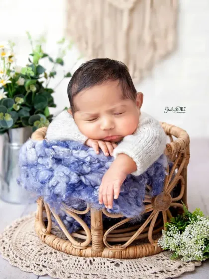 Look at those adorable chubby cheeks. This little guy is sleeping so soundly in a basket, perfectly posed to show off all his cute newborn features.
