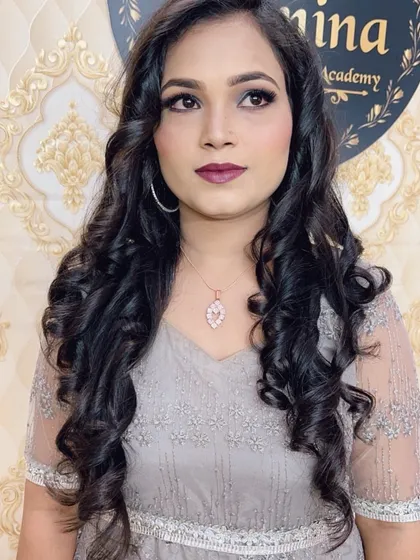 A portrait of the client, showing how the hairstyle and makeup come together to create a polished and glamorous look for her grey evening gown.