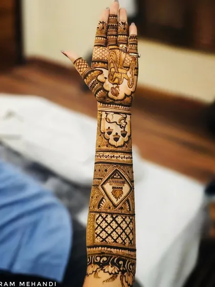 This is a full forearm design showcasing a variety of patterns. From the detailed jaali (net) work to the bold central motifs, this style is for grooms who appreciate complex and dense henna art.