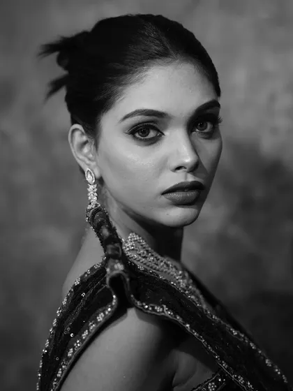 A dramatic black and white shot of the model, highlighting the structure and definition of the makeup.