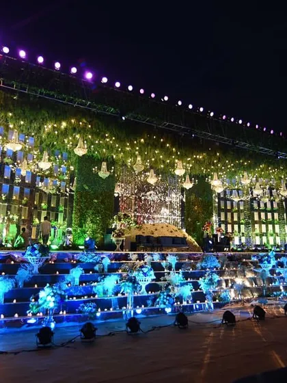This was one of my most ambitious stage designs. A multi-tiered structure with mirrored panels, lush greenery, and dozens of chandeliers, creating a breathtaking focal point for a very large reception.