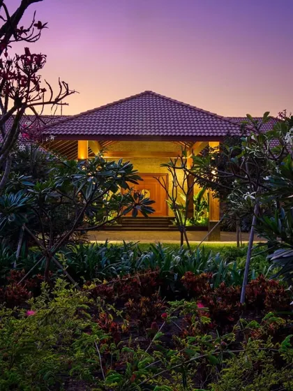At twilight, the entrance to this home becomes a magical space. Uplighting on the surrounding trees and shrubs creates a warm, inviting glow, highlighting the path to the front door.