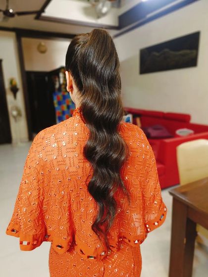 The final look: a long, wavy high ponytail that is both playful and elegant, perfect for a sangeet or cocktail night.