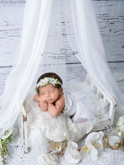 A princess in her white canopy bed, surrounded by lilies. The sheer fabric and all-white theme create a light, airy, and heavenly feel.