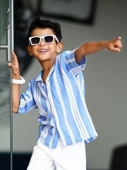 A cool and confident pose from a five-year-old's birthday shoot. His personality shines in this stylish outdoor shot.