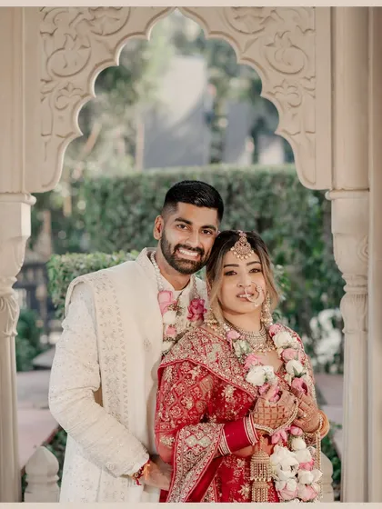 A classic, warm-toned portrait of the newly married couple, framed by a beautiful archway that adds depth and elegance.