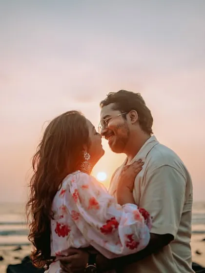 A classic romantic silhouette of a couple against a beautiful sunset on a Mumbai beach. Golden hour light creates a magical, timeless feel for pre-wedding portraits.