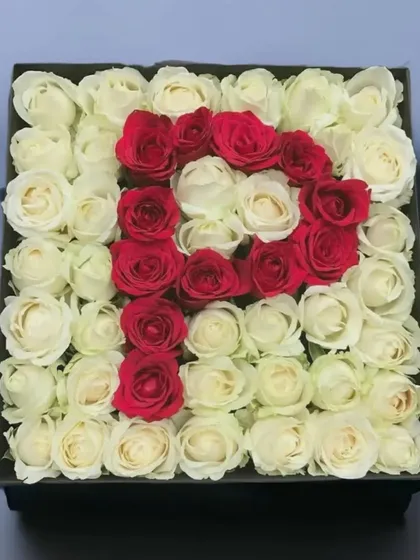 Make it personal with our custom monogram bouquets. This arrangement showcases the letter 'P' crafted from vibrant red roses, set against a backdrop of pure white roses in a classic square box.