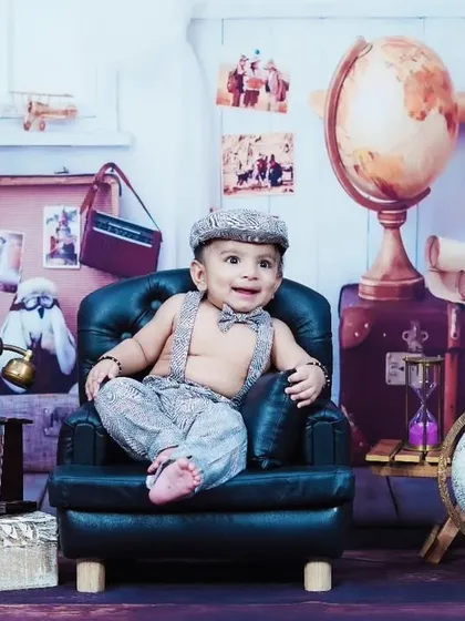 A full view of our vintage traveler theme, featuring a dapper baby boy in a miniature armchair.