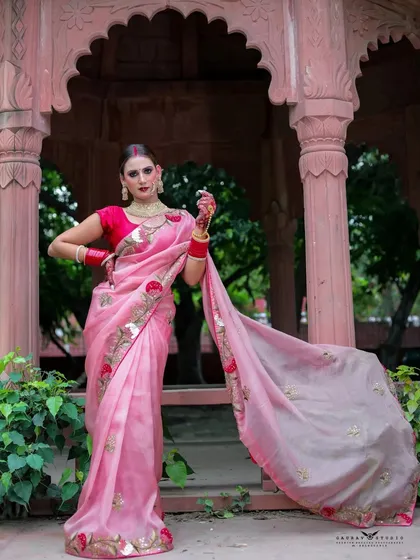 A full-length portrait showing the saree's pallu flowing in the breeze, creating a dynamic and graceful image.