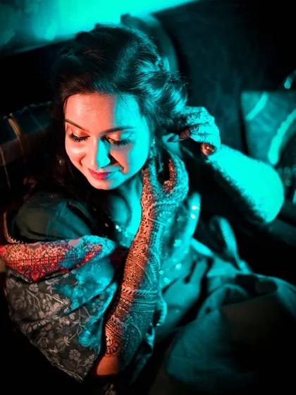 A creative portrait of a bride during her Mehendi night. I used colored lighting to create a dramatic and modern feel, highlighting the beauty of her henna.