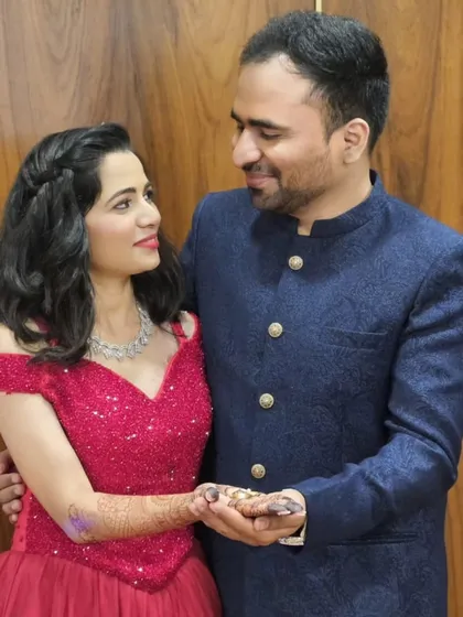 A sweet moment during their ring ceremony. The bride's hennaed hand holding the rings is a beautiful detail, complemented by her sparkling red gown.