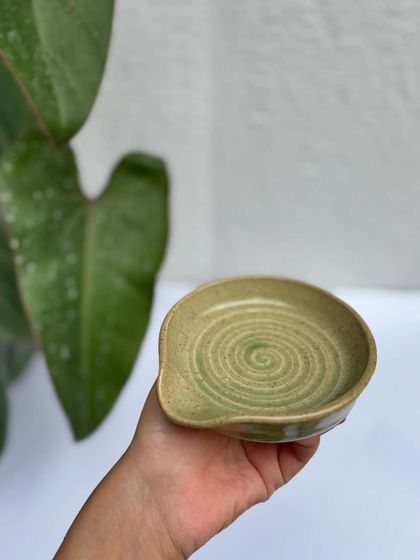 A spoon rest in our Green Celadon glaze. The spiral is defined by a subtle white drip, a happy accident from the kiln.