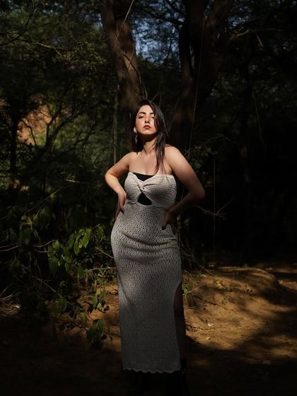 A full-length shot from the forest shoot, with shadows and light playing on the white dress.