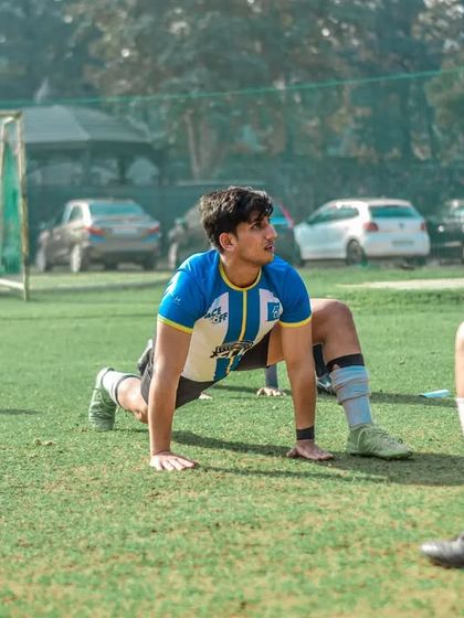 Players stretch and warm up before a corporate football match.