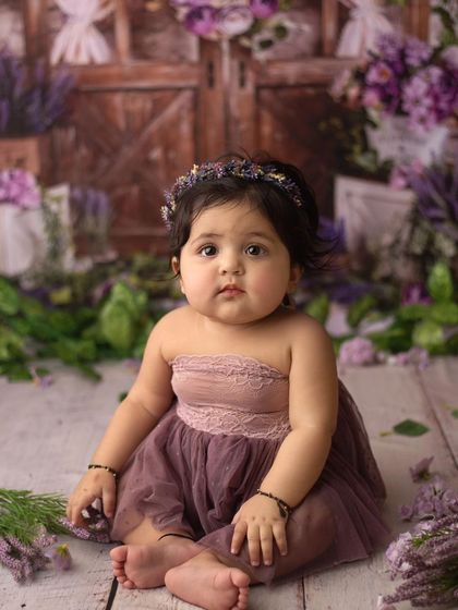 Another heart-melting moment. This little one's calm and curious expression is so beautiful against the rustic floral backdrop.
