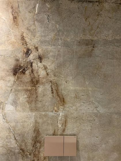 A close-up of a marble wall, where the natural veining creates a unique, abstract pattern. We often use large format tiles to showcase the inherent beauty of the stone.