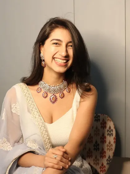A happy client glowing in her custom-made pink stone and Polki jewellery set. Her smile says it all.