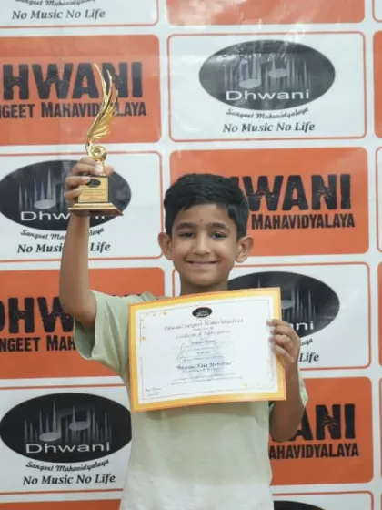 A young boy joyfully holds up his trophy, a proud winner at our art festival.