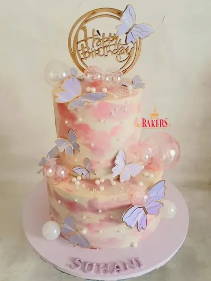 A completely no-fondant butterfly theme cake for a birthday celebration. The pink and purple marble effect with delicate wafer paper butterflies creates a dreamy and whimsical look.