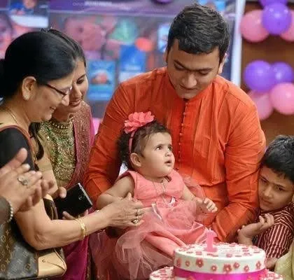 The family gathers around the birthday girl and her cake. These moments, surrounded by loved ones, are the heart of any celebration.