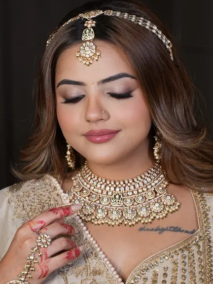 A close-up of the model, her hand delicately placed on her chin, showcasing her beautiful hathphool and choker.