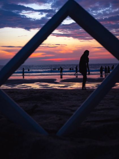 Playing with frames within the frame. I used a physical frame to silhouette a person against the dramatic sunset on the beach, creating a focused and artistic composition.