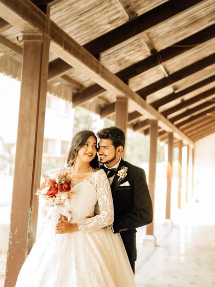 A tender moment between the couple in a rustic corridor. The natural light and architectural elements frame them beautifully in this wedding portrait.