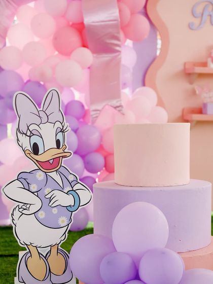 A closer look at the Daisy Duck prop and the beautiful pastel pink and purple cake, surrounded by a sea of matching balloons.