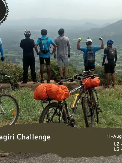 The 'Melagiri Challenge' takes you to incredible viewpoints overlooking the vast landscape. Here, a group of riders celebrates reaching the top, with their bikes and gear ready for the next adventure.